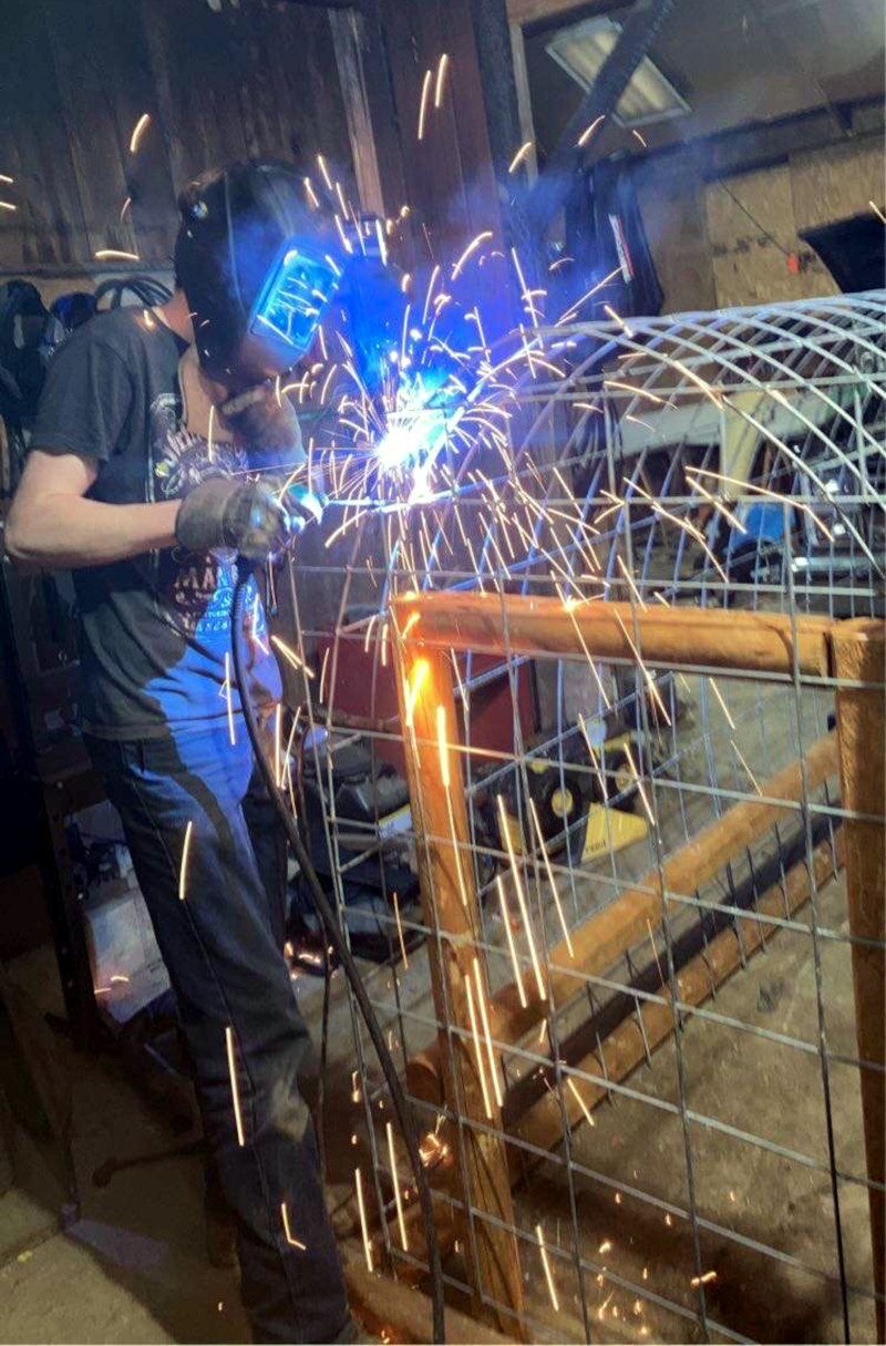 Adam Carr welds a chicken coop. (Photo Provided)